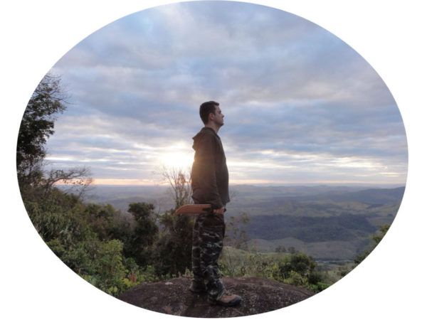Fernando Weishaupt em cima de uma pedra sentindo a energia após uma trilha foto com bordas arredondadas